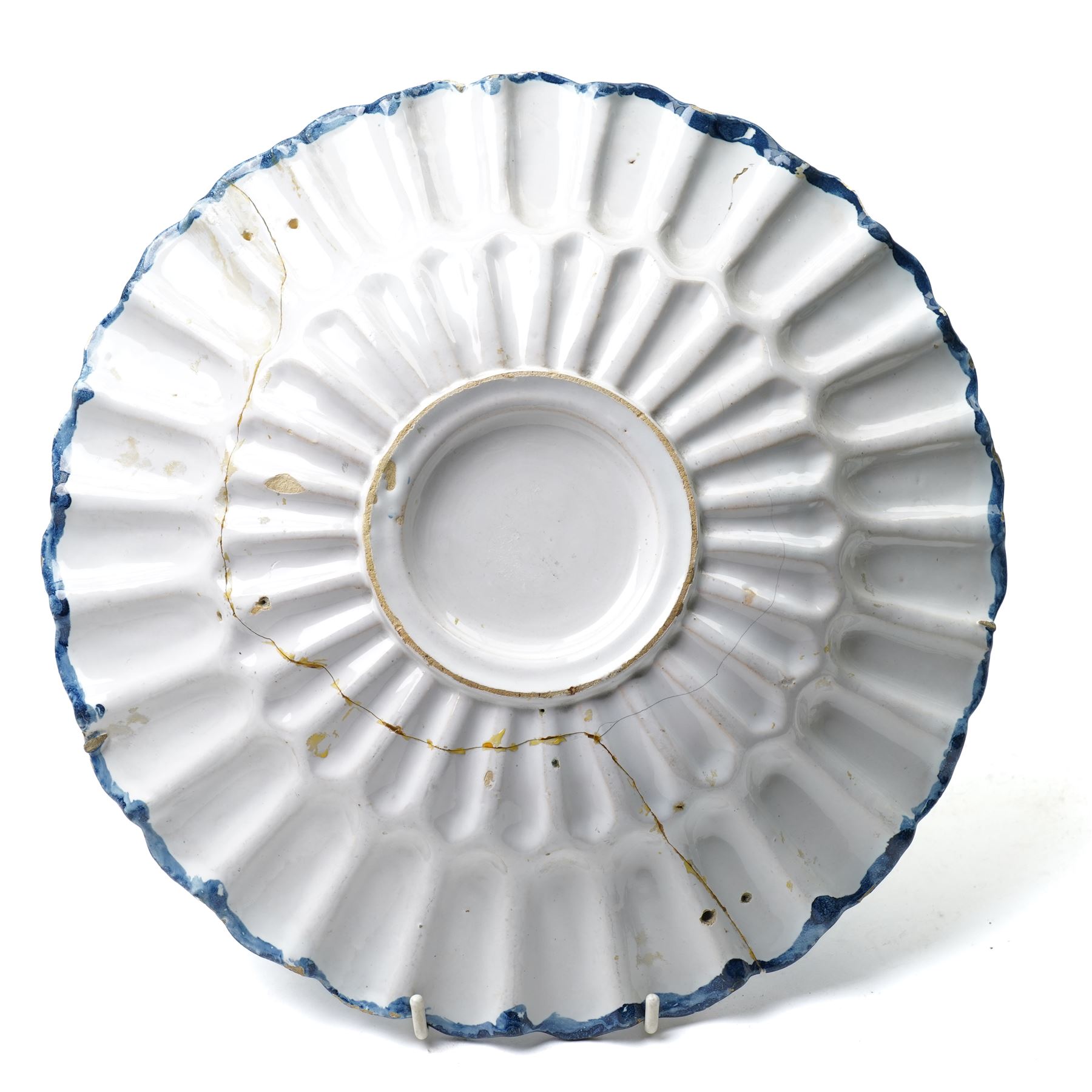 18th century Dutch Delft plate of fluted design decorated in blue and white with figures in a landscape D29cm and a Dutch Delft vase decorated in blue and white with oriental flowers H21cm (2)