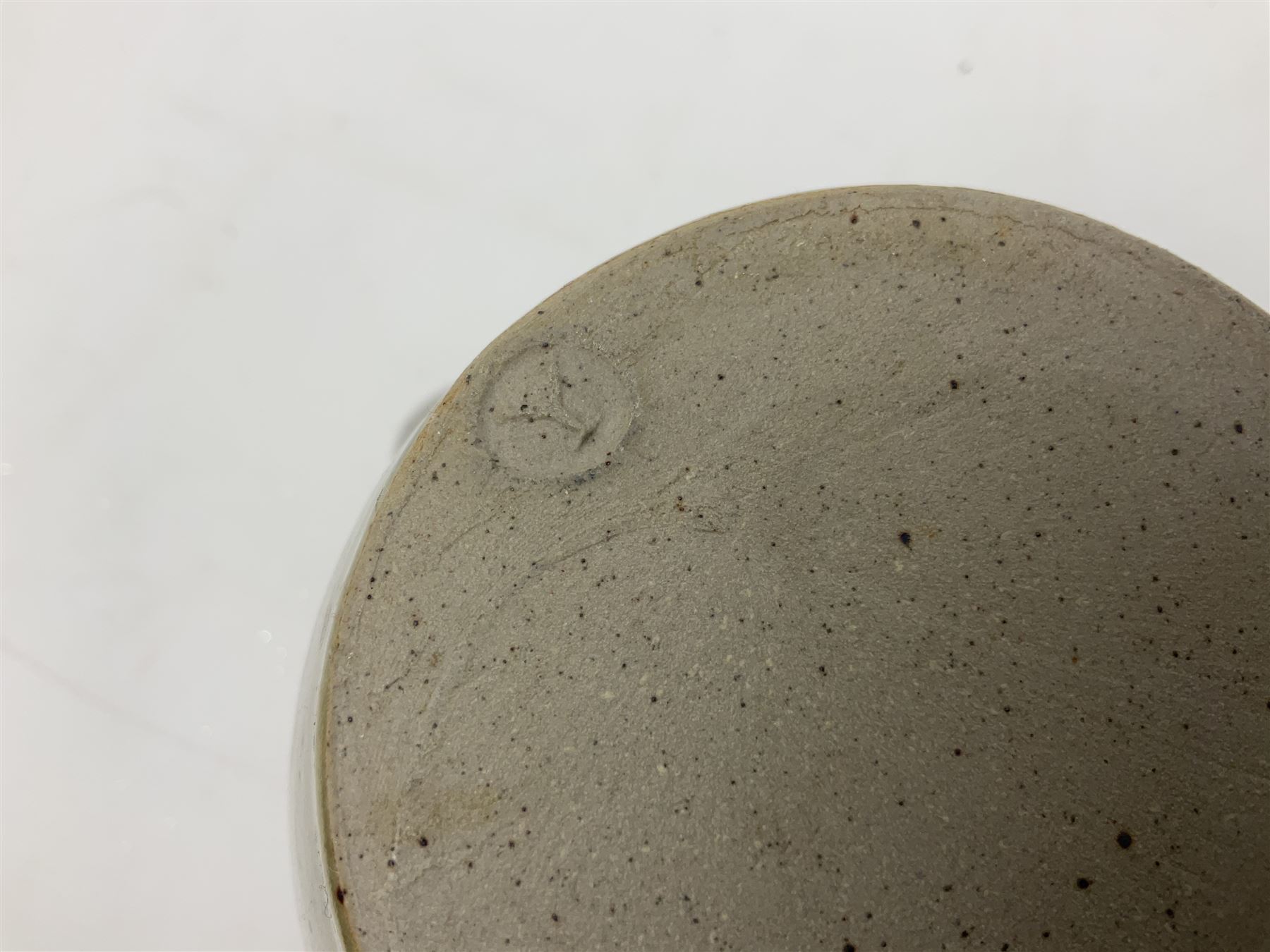 Michael Leach (British 1913-1985) for Yelland pottery; two large glazed stoneware plates with dark brown stylised decoration upon oatmeal ground, together with a jug in merging blue, green and brown, all with impressed marks beneath, largest plate D37cm