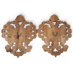 Carved wooden wall plaque, decorated with foliate scrolls, with two reproduction swords attached, together with five other wooden plaques with foliate scrolls and shields