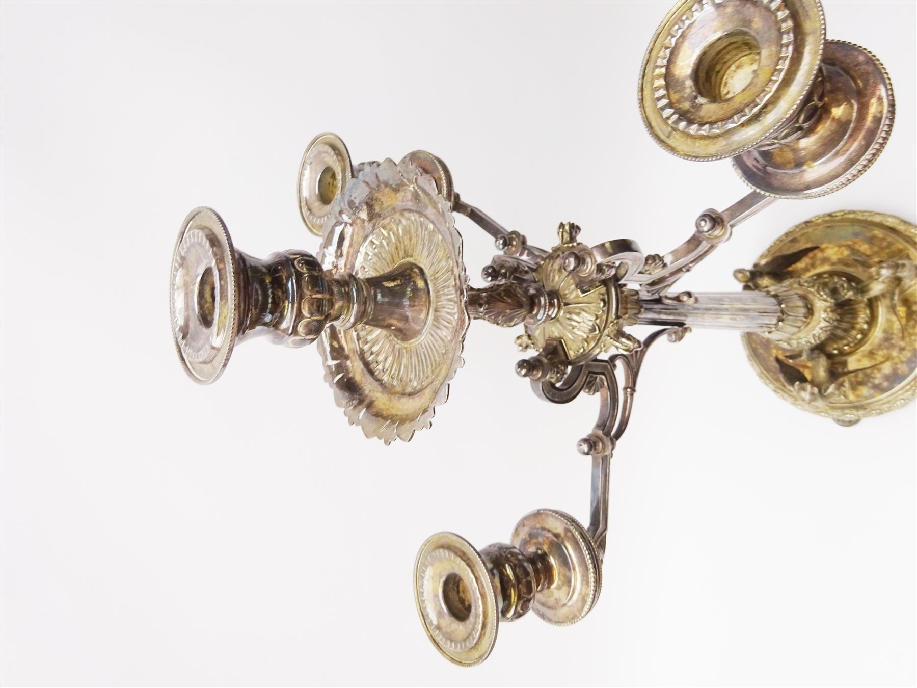 A large Victorian Thomas Bradbury & Sons silver plated candelabrum, the circular base with flower head border upon three domed feet, supporting a central knopped and fluted column flanked by three zoomorphic creatures, leading to a central socket with removable nozzle above a large palmette detailed drip pan, and three scrolling branches with conforming sockets and nozzles, with maker's silver plate mark and Victorian registration lozenge beneath, H62.5cm
