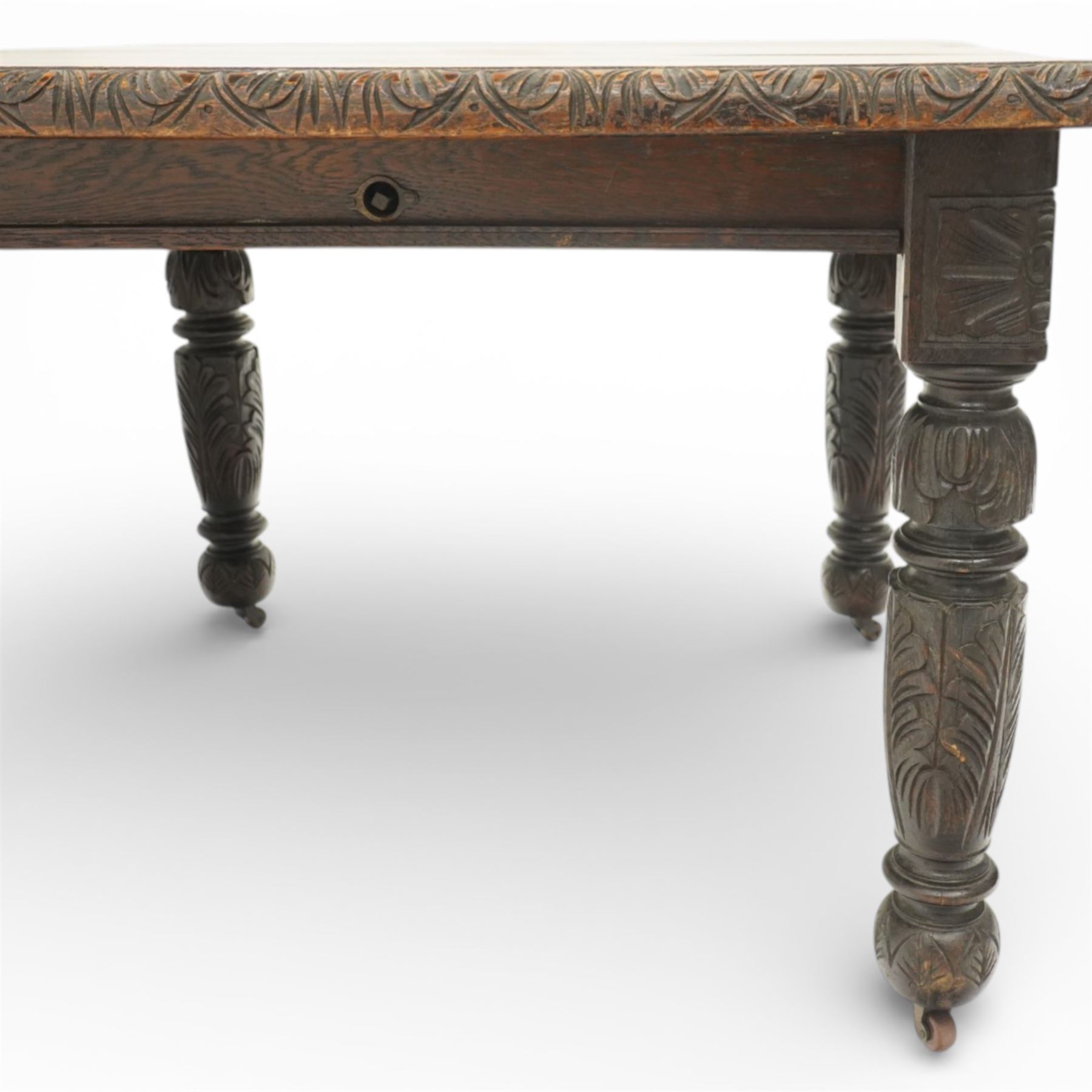 19th century heavily carved oak extending dining table, with winding mechanism and a gadrooned edge, over block and turned supports terminating in castors, extends to 147cm
