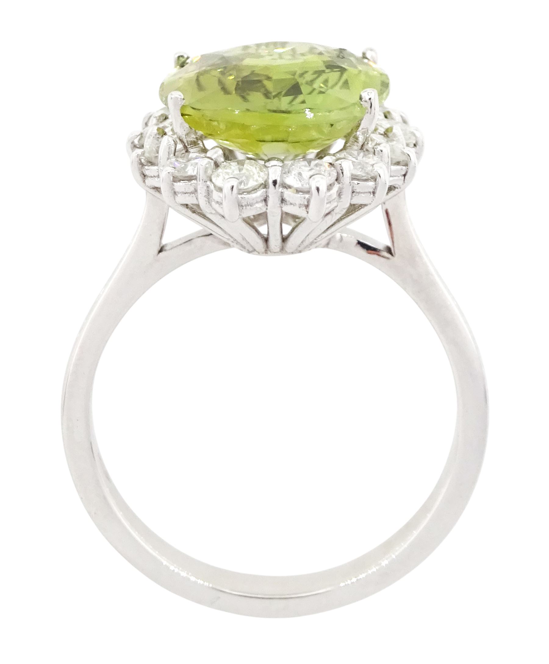 18ct white gold alexandrite and diamond cluster ring, the natural oval cut green alexandrite of approx 5.95 carat, surrounded by fourteen round brilliant cut diamonds, stamped 750, total diamond weight approx 0.80 carat
