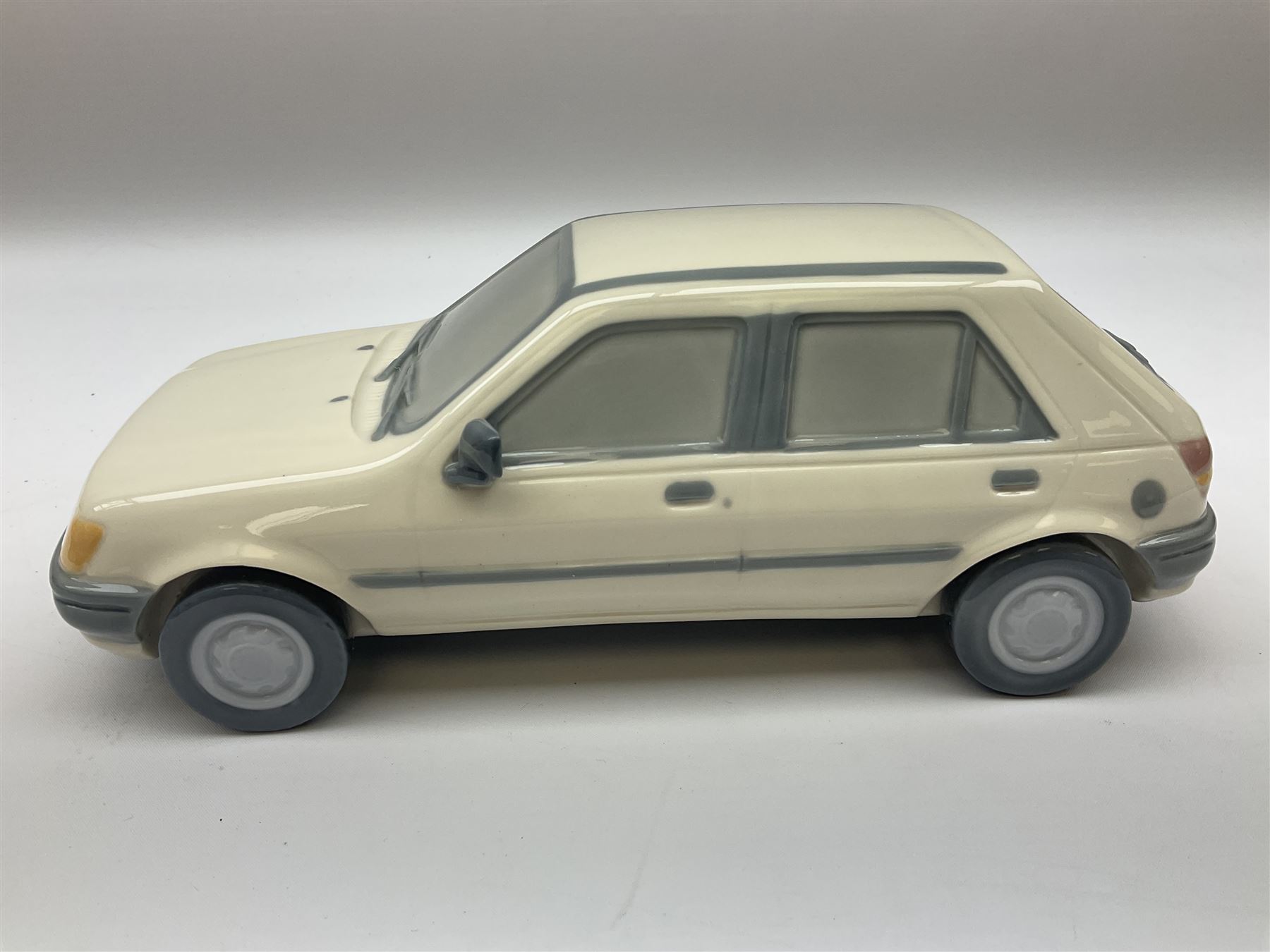 Lladro figure, Ford Fiesta, modelled as a Ford in beige, special commission by the Ford factory in Valencia, original box, no 7608, year issued 1989, year retired 1989, H9cm 