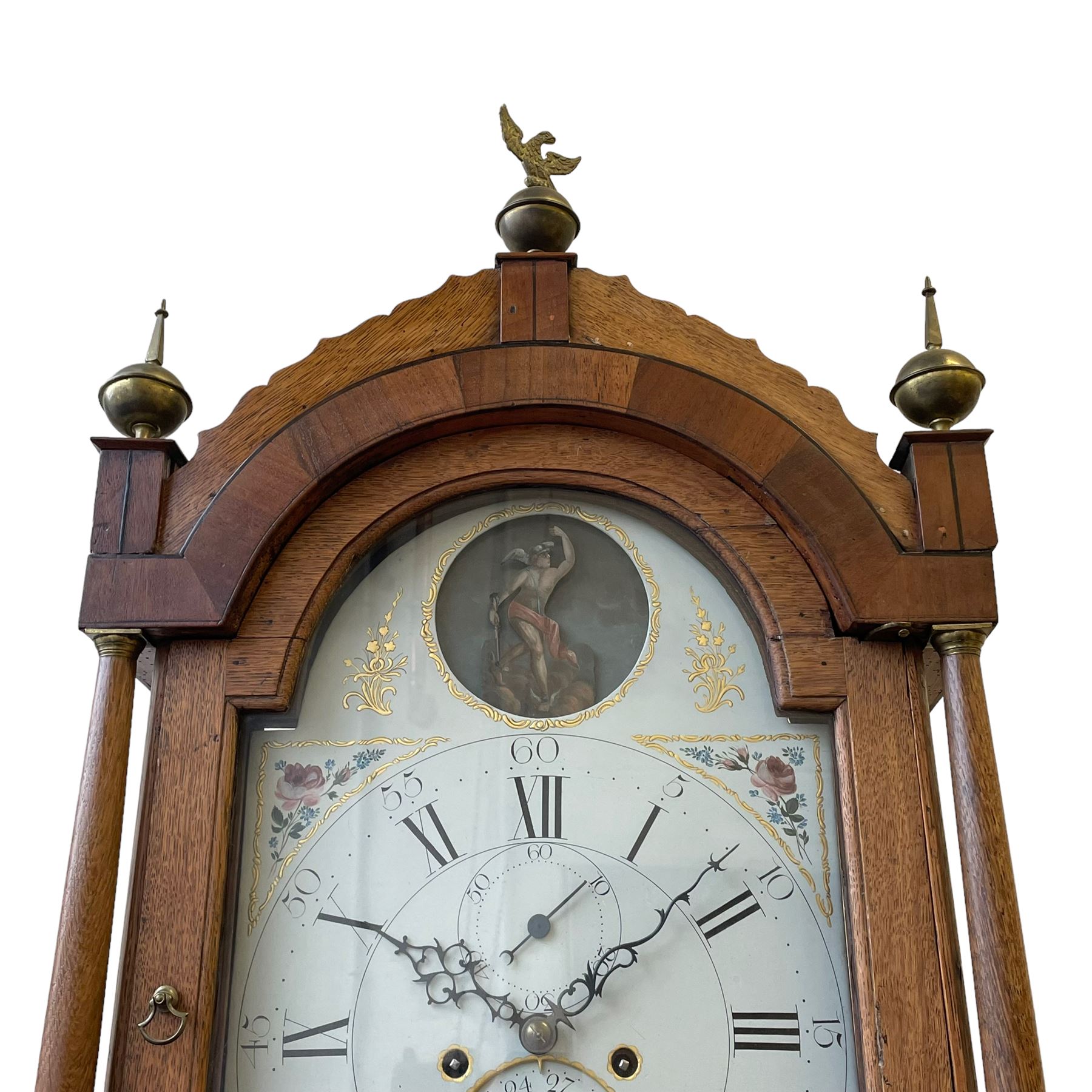 William Gostling of Diss  (Norfolk)-  Late 18th century 8-day oak longcase clock c1780-90, break arch top with scalloped cresting and three brass finials, glazed break arch hood door flanked by turned pilasters with brass capitals, trunk with a long trunk door and rounded top on a square plinth with an applied and shaped skirting, early painted Wilson of Birmingham dial with Roman numerals and five minute Arabic's, matching steel hands and second pointer, arched square ended calendar aperture with date disc behind, floral spandrels within gesso borders and a painted rocking automaton representing Mercury to the break arch, dial pinned via a false plate to a weight driven rack striking movement with a recoil anchor escapement, striking the hours on a cast bell. With pendulum weights and key. 
William Gostling (II) is recorded as working in Diss from 1774 to 1797, succeeded by widow Anne and son George . The dial of this clock is illustrated and discussed in detail in M.F. Tennants book 