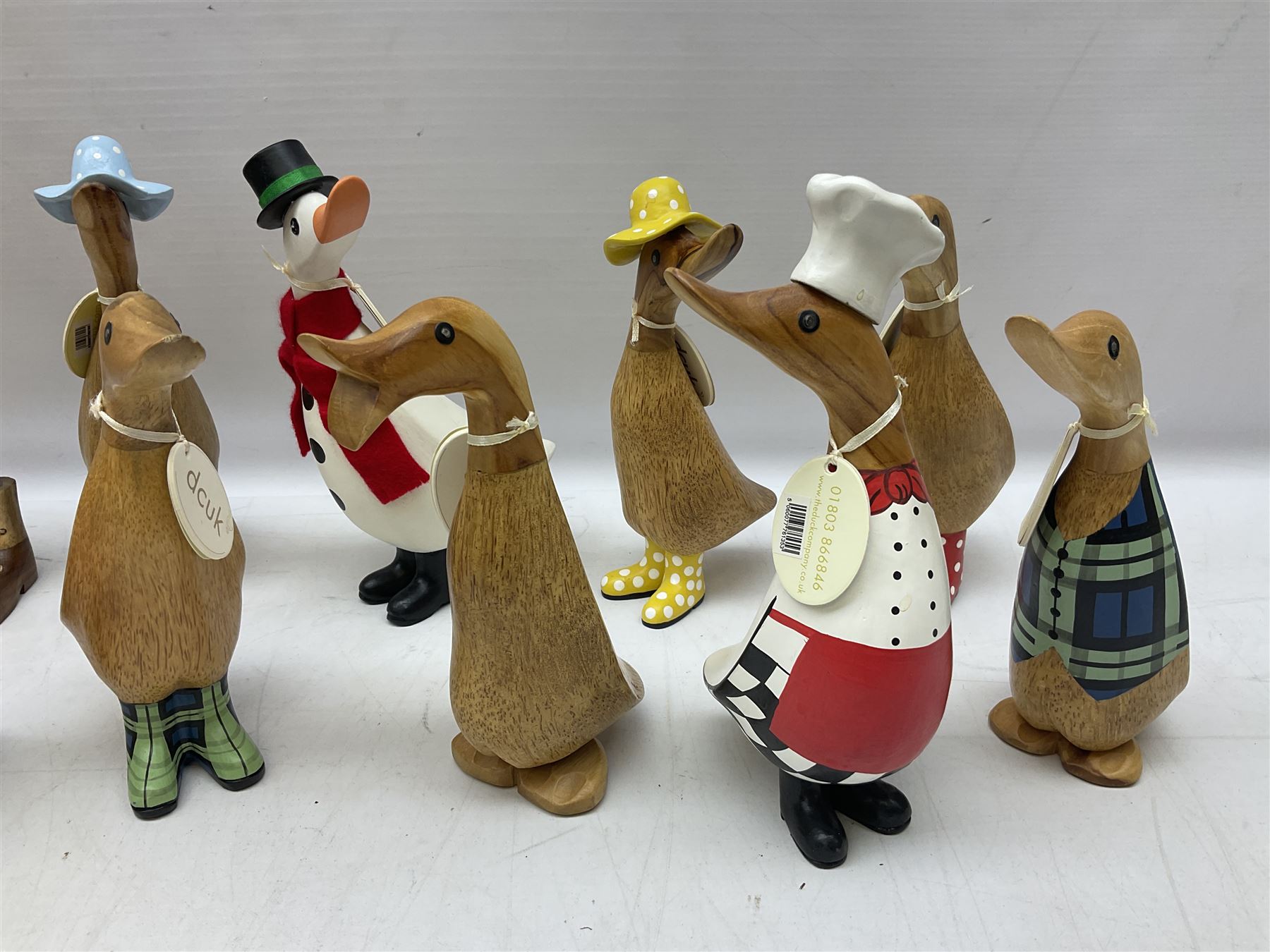 Quantity of the Duck Company UK DCUK carved bamboo root ducks, modelled wearing rain hats and rain boots etc, together with other similar carved wood ducks, tallest H26cm