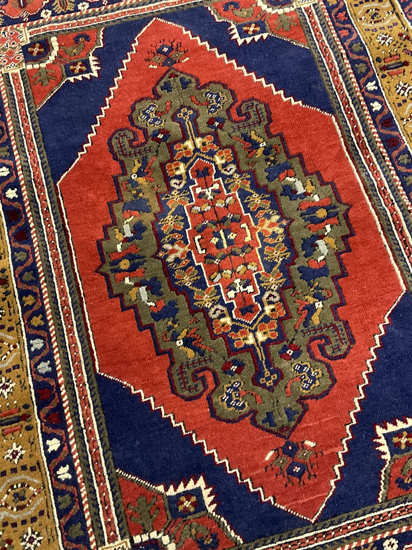 Turkish Taspinar rug, blue ground with central lozenge and medallion, the outer borders decorated with stylised motifs