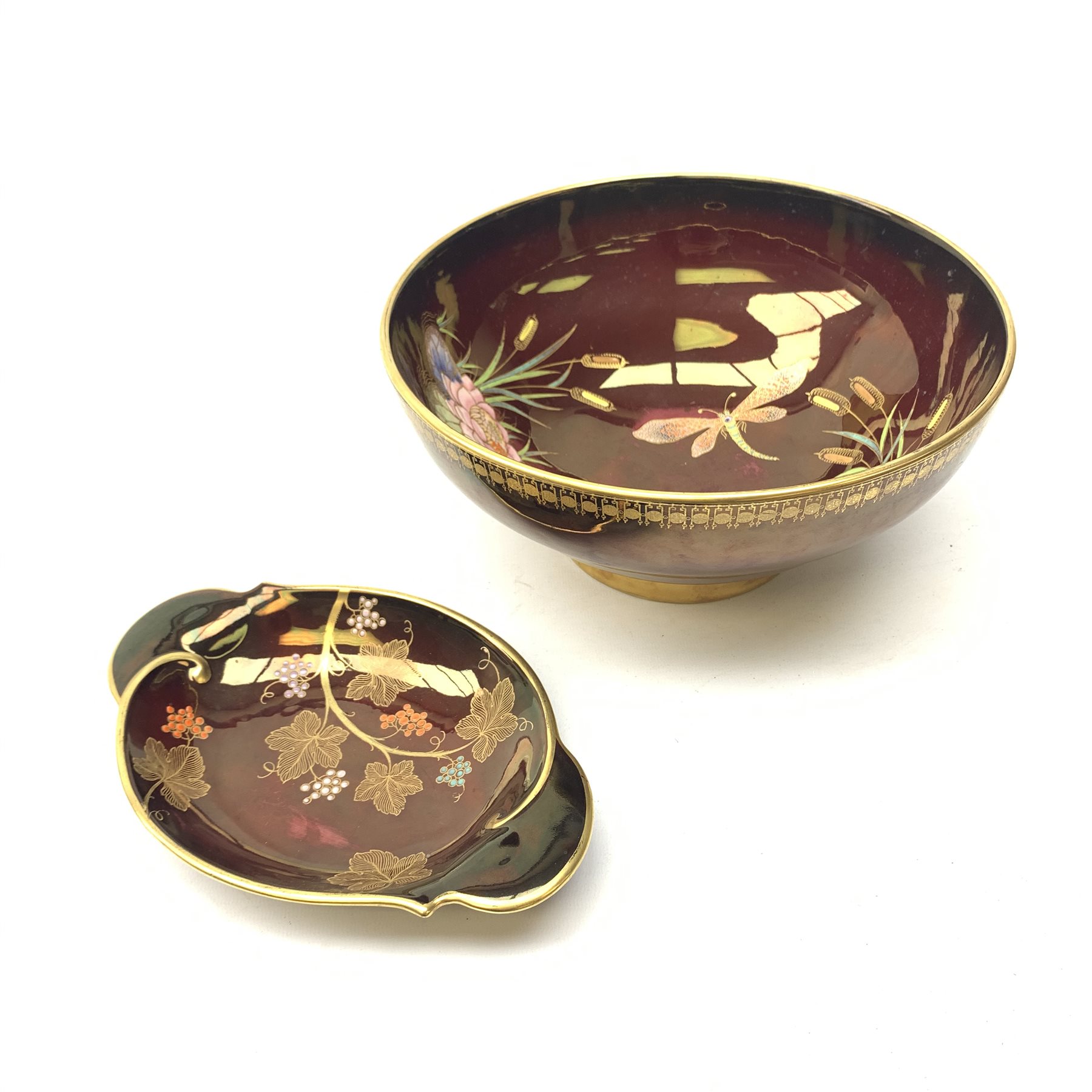 A large Carlton Ware Rouge Royale bowl, the interior decorated with dragonflies, lilies and bulrushes in enamel and gilt, with marks beneath, D25.5cm, together with a Carlton Ware Rouge Royal dish, decorated with grape vines, with marks beneath, L21.5cm. 