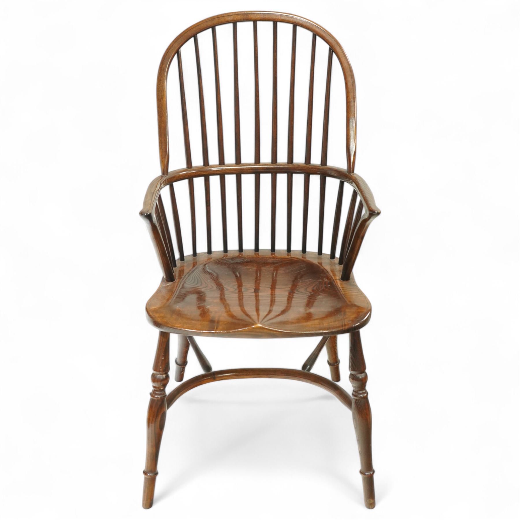 Late 19th century ash and elm Windsor armchair, with hooped back and spindle supports, shaped elm saddle seat, on turned legs united by crinoline stretcher