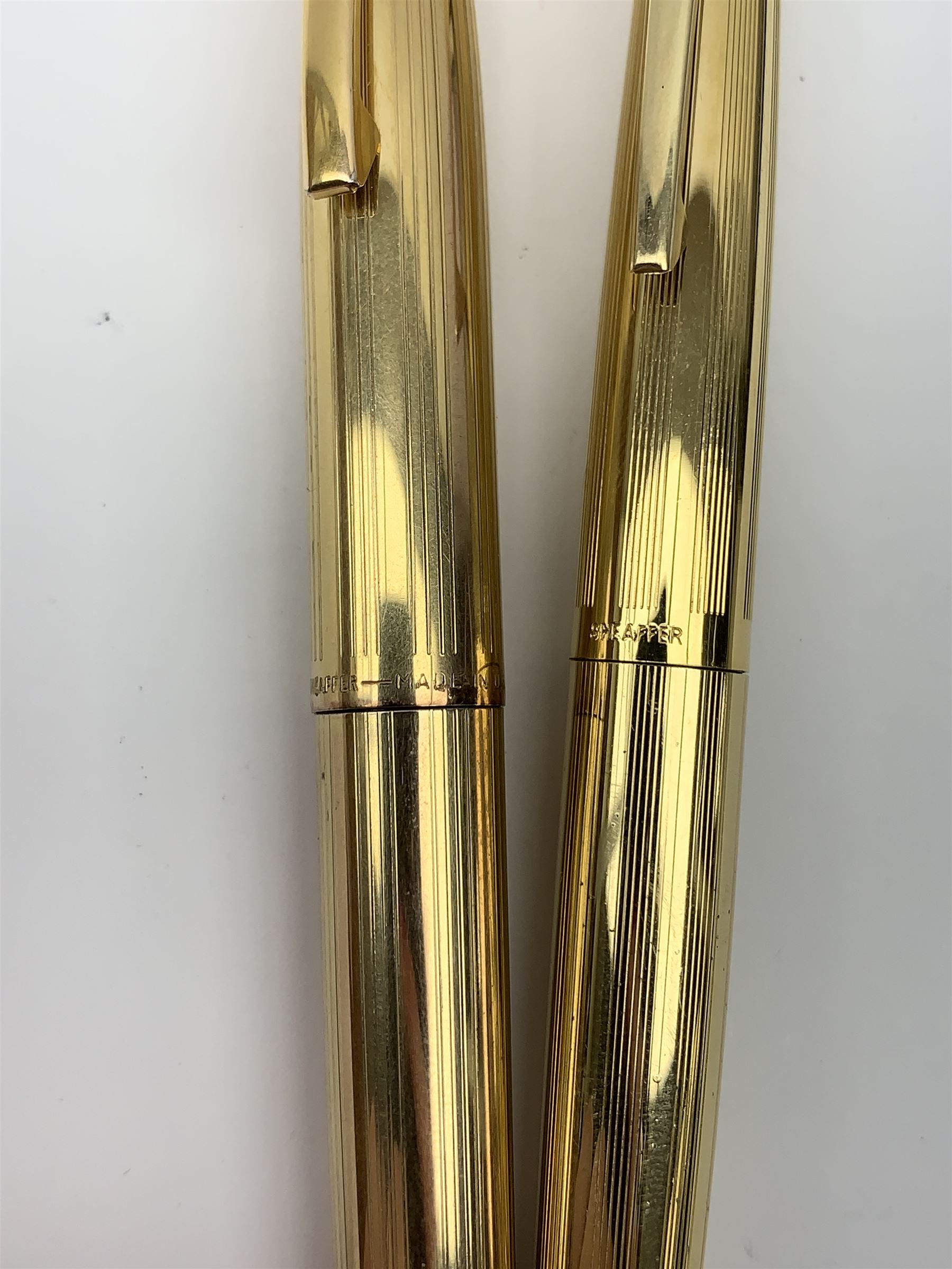 A Sheaffer Imperial Triumph fountain pen, the electroplated body with vertical band decoration, and nib marked 14K 585, together with a further Sheaffer fountain pen, with similarly decorated electroplated body, and nib marked 14K, in unassociated case. 