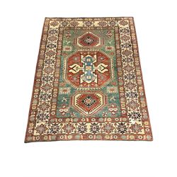Kazakh rug, pale green ground field with three part medallion, three band border decorated with stylised plant motifs