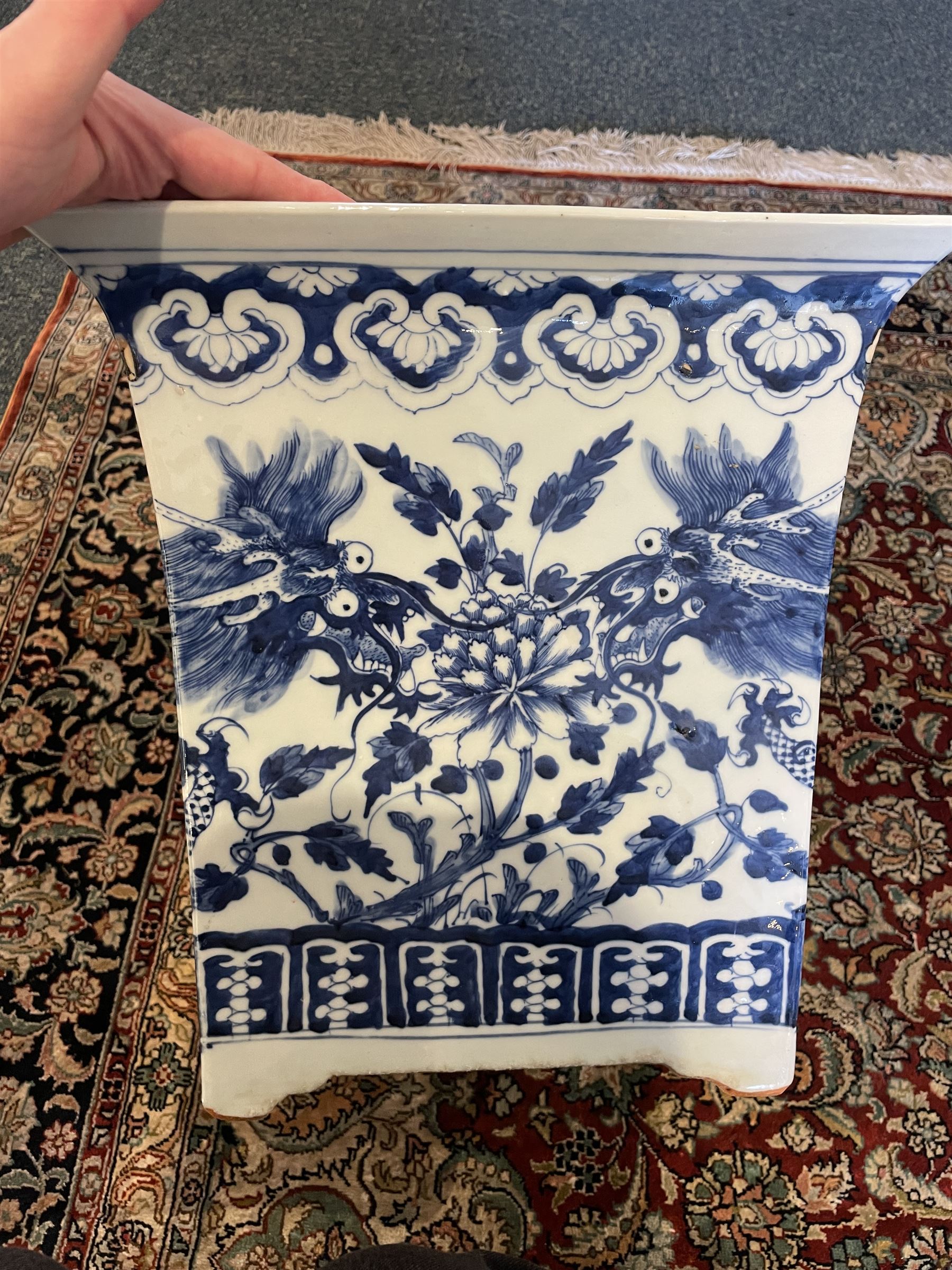 Chinese blue and white planter and stand, each of square slightly tapering and flared form, the planter decorated with two dragons and blossoming peonies, between stylised borders, the stand decorated with flower heads and vines, planter H30cm W29cm, stand H7cm D28.5cm
