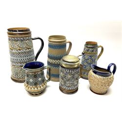 Five Victorian Doulton Lambeth Silicon Ware jugs, and a tankard, the largest example with relief moulded foliate decoration in tones of brown and blue, H24cm. 