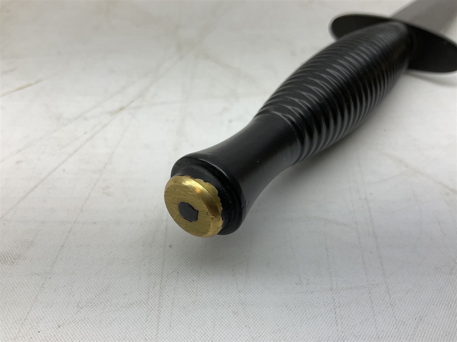 Gulf War period commando knife with 17cm double-edged steel blade etched with the crest and motto 'By Strength and Guile', blackened cross-piece and grip; in webbing scabbard L31cm overall