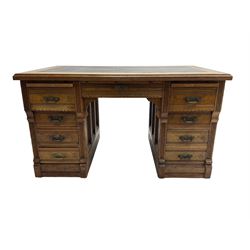 Tees & Co Montreal - early 20th century oak knee-hole desk, rectangular top with inset leather writing surface and reeded edge, fitted with two brushing slides,  central frieze drawer flanked by six short drawers and one double drawer, the twin pedestals wit panelled sides and reeded uprights