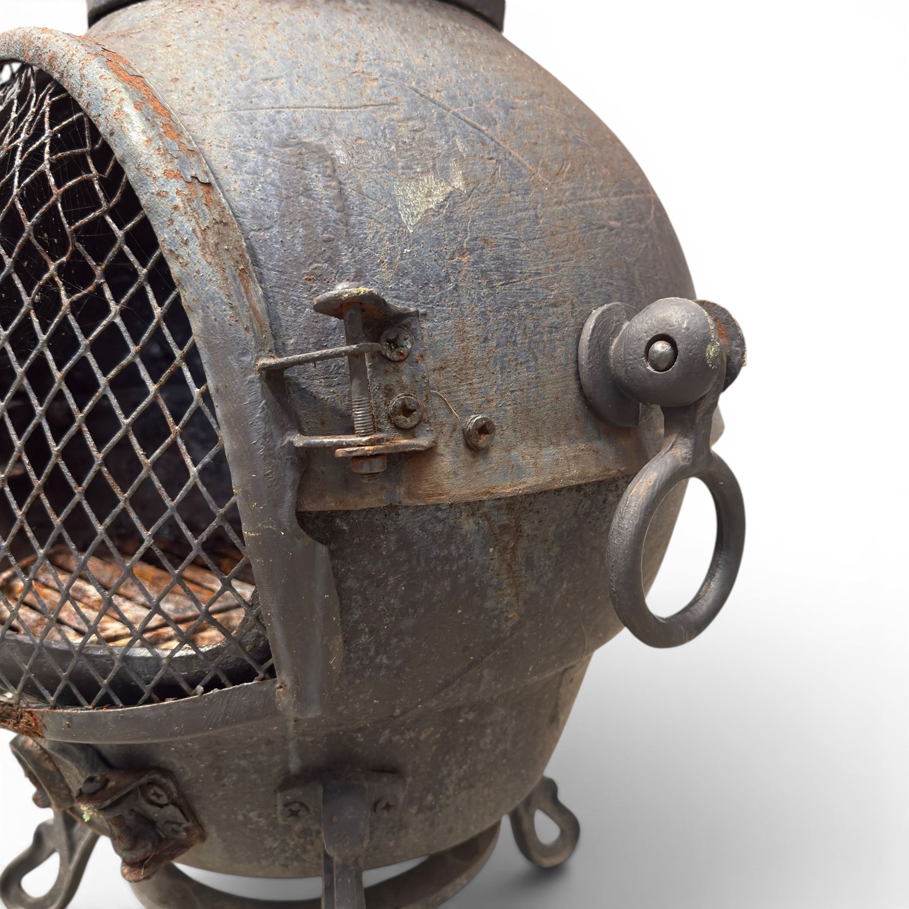 Cast iron garden chiminea, with mesh front spark guard, flue chimney on three splayed legs, finished in black.