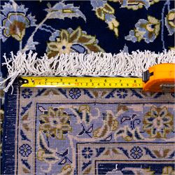 Central Persian Kashan hand-knotted carpet, deep indigo blue field densely decorated with all-over vine, palmette and flowering sprays arranged in a symmetrical pattern enclosed by broad navy border of stylized palmettes, and foliate vine decoration between multiple guard stripes, with cotton fringe ends 
