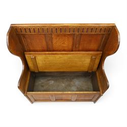 Early 20th century oak box settle, panelled back with arcaded carved rail, swept sides and arms, hinged seat with storage, panelled front