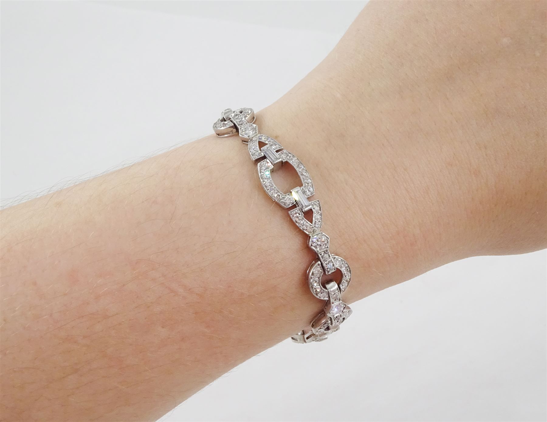 Art Deco platinum diamond bracelet, circa 1920, articulated openwork circular and geometric links, milgrain set with old cut diamonds and baguette cut diamonds, total diamond weight approx 3.85 carat