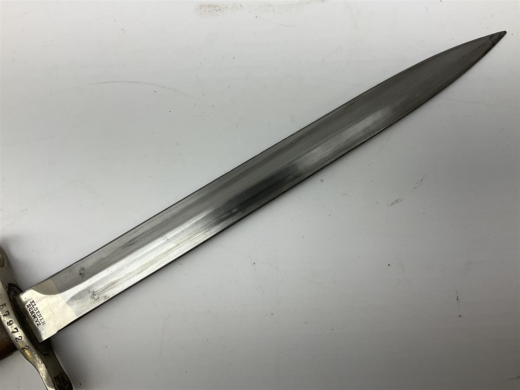 British Enfield 1907 model SMLE bayonet, with 43cm fullered steel blade and metal mounted leather scabbard L58cm overall; and Schmidt-Rubin Model 1918 bayonet the 30cm steel blade marked Elsener Schwyz No.579722; in steel scabbard with leather frog marked G. Bertolini Sellaio Vira/G.Tic 79 L45cm overall (2)