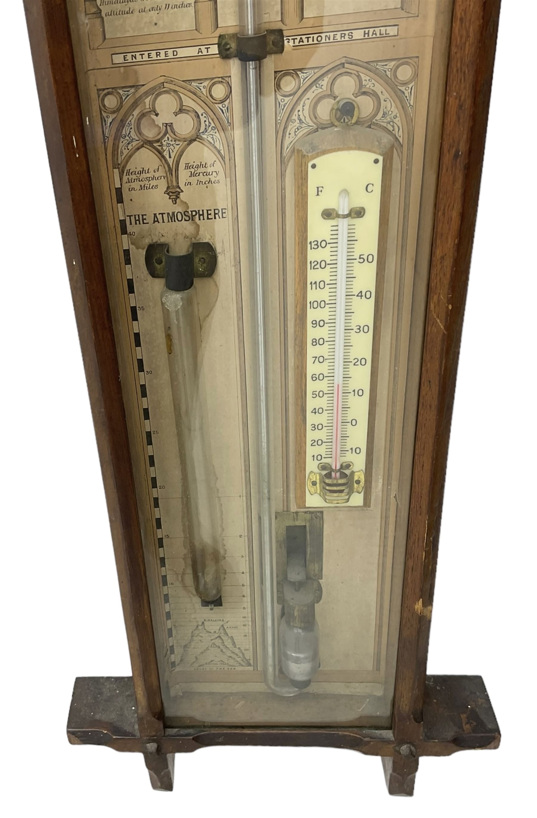 Oak cased Admiral Fitzroy barometer c1890 - with original full height paper scales annotated with Fitzroy's remarks and observations, brass sliding pointers above a Fahrenheit and centigrade spirit thermometer and storm glass, large bore bulb cistern tube with a mechanical sealing tap, in a fully glazed reformed gothic influenced case with chamfered moulded uprights, top, and base.