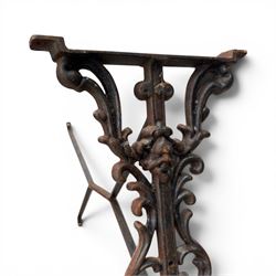 Pair of Victorian cast iron table end supports, of pierced and scrolling foliate design with central masks, united by X-form stretcher, with later top