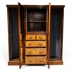 Edwardian figured walnut triple combination wardrobe, moulded cornice above a three part wardrobe, central section with figured walnut panelled doors, above two over three drawers, flanked by mirrored doors enclosing hanging hooks, raised on a plinth