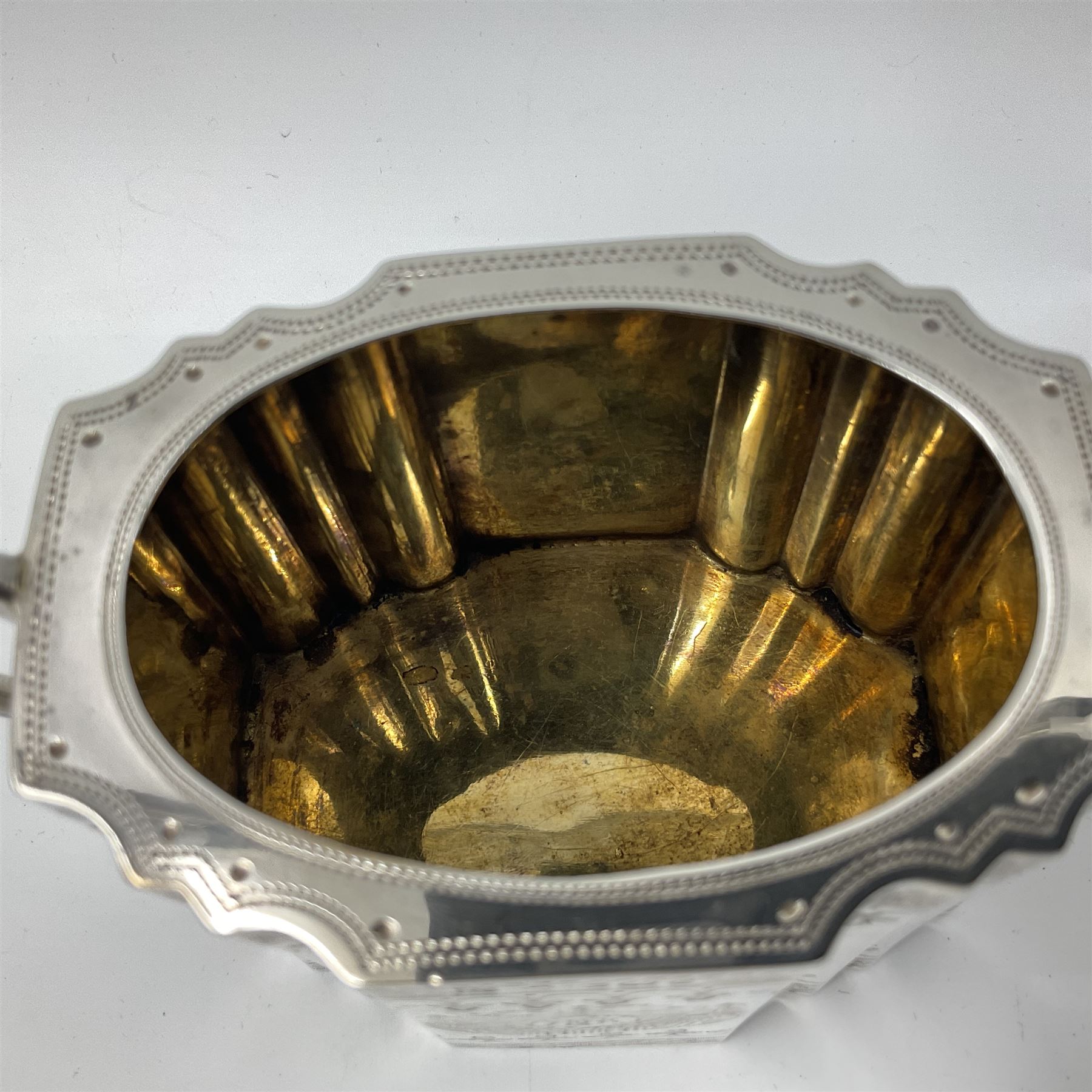 Victorian three-piece silver tea service, comprising teapot, twin handled open sucrier and milk jug, of oval form with shaped rim and C handles, each engraved with crests and bands of strapwork decoration, the milk jug and sucrier with gilt interiors, hallmarked Josiah Williams & Co, Exeter 1881, the teapot with ivory insulators and finial, all contained with a tooled leather, blue silk and velvet lined fitted case, retailed by West & Sun, Dublin 
This item has been registered for sale under Section 10 of the APHA Ivory Act