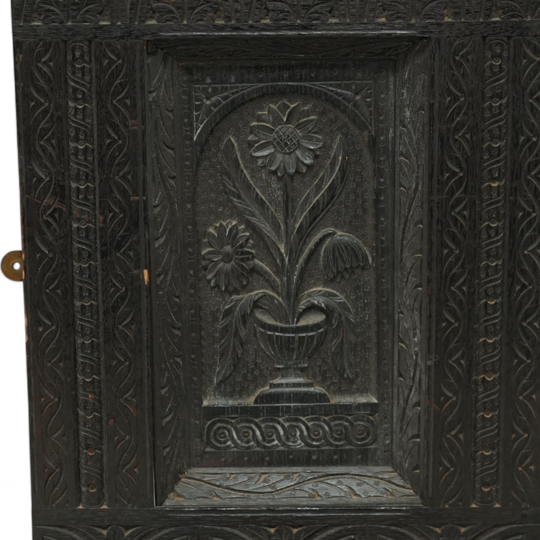 Victorian heavily carved oak wall mirror, lunette and foliage carved frieze over central bevelled mirror and flanking panels carved with floral urns, the upright frame decorated with geometric pattern chip carvings, lunette carved lower rail 