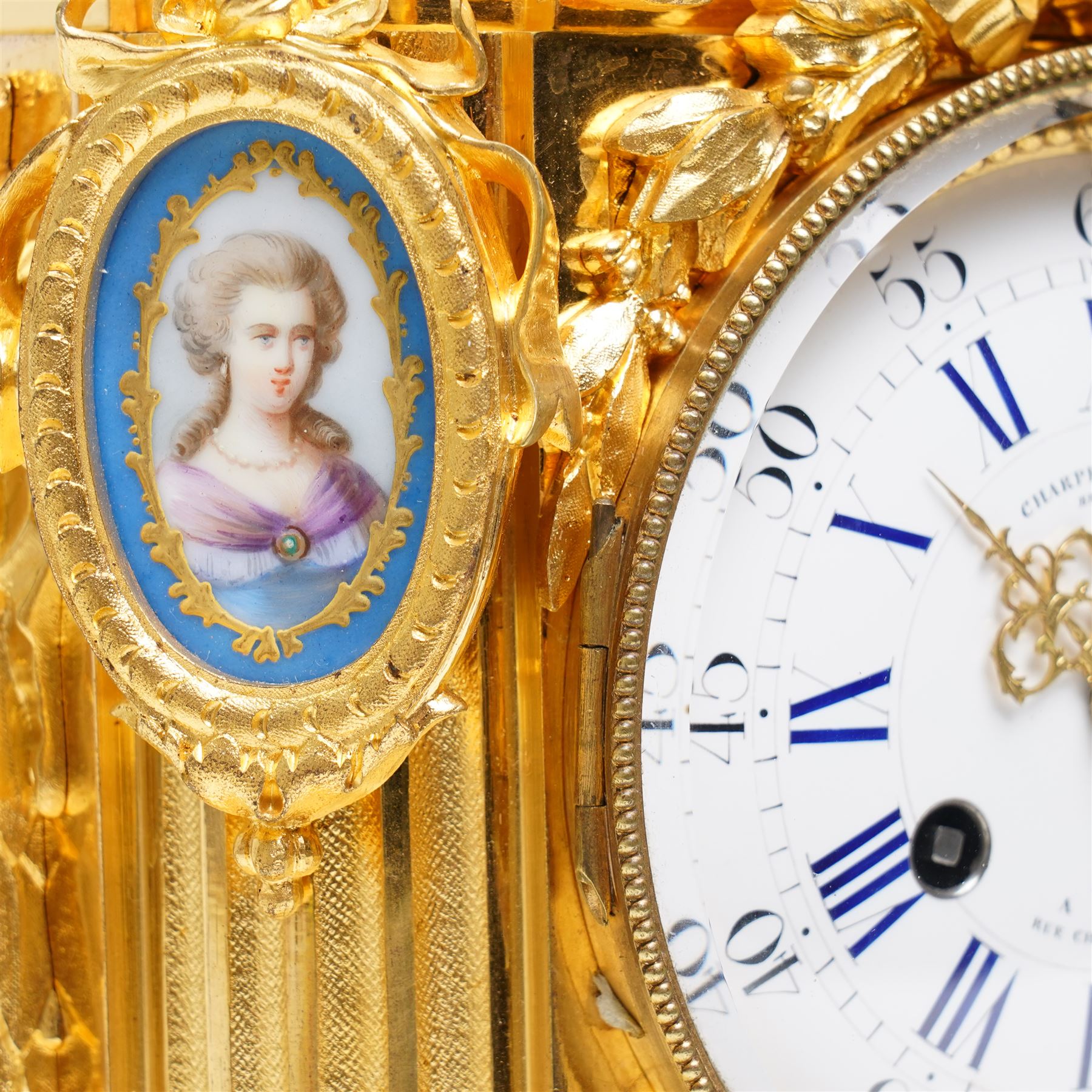 Charpentier & Cie-French 8-day mantle clock c 1860, in an ormolu case with Sevres style plaques, fluted pedestal case decorated with acanthus leaves and floral swags, surmounted by a putto and raised on toupie feet, convex enamel dial with Roman numerals, minute track and five-minute Arabic's, with makers name and Louis XVI style gilt hands, Parisian twin train movement with rack striking, sounding the hours and half-hours on a bell. With pendulum and key.
Charpentier & Cie, operated in Paris from around 1830 to 1860. They are especially well-known for their clock and garniture sets, as well as for their works of bronze. With pendulum and key.

