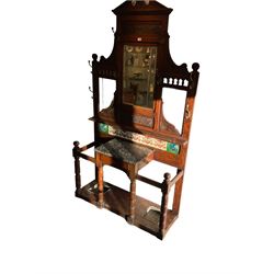 Edwardian oak hallstand, shaped pediment with egg and dart cornice and carved panelled frieze, bevelled mirror above shelf, the lower section with tiled back over marble-topped single drawer, turned supports joined by an undertier with fitted umbrella stands