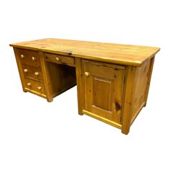 Large pine desk, rectangular top over four drawers, slide and panelled cupboard