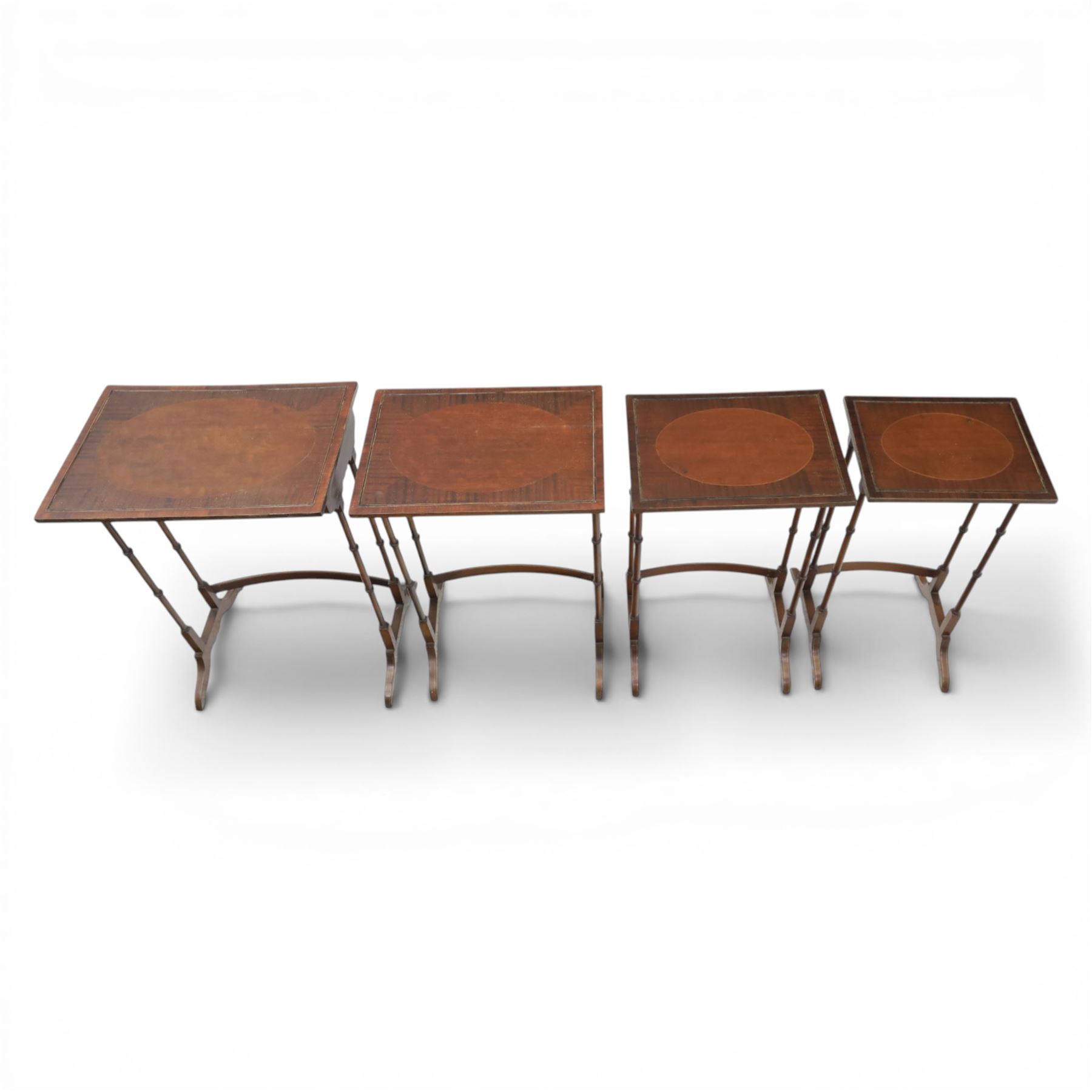 20th century mahogany quartetto nest of tables, the rectangular tops with oval inlay, upon turned knopped supports, united by a curved stretcher, raised upon outswept feet