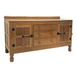  'Mouseman' oak sideboard, raised back with hand adazed above three central graduating drawers flanked by two panelled doors with wrought iron hinges and latches by Robert Thompson of Kilburn W152cm, H82cm, D48cm  