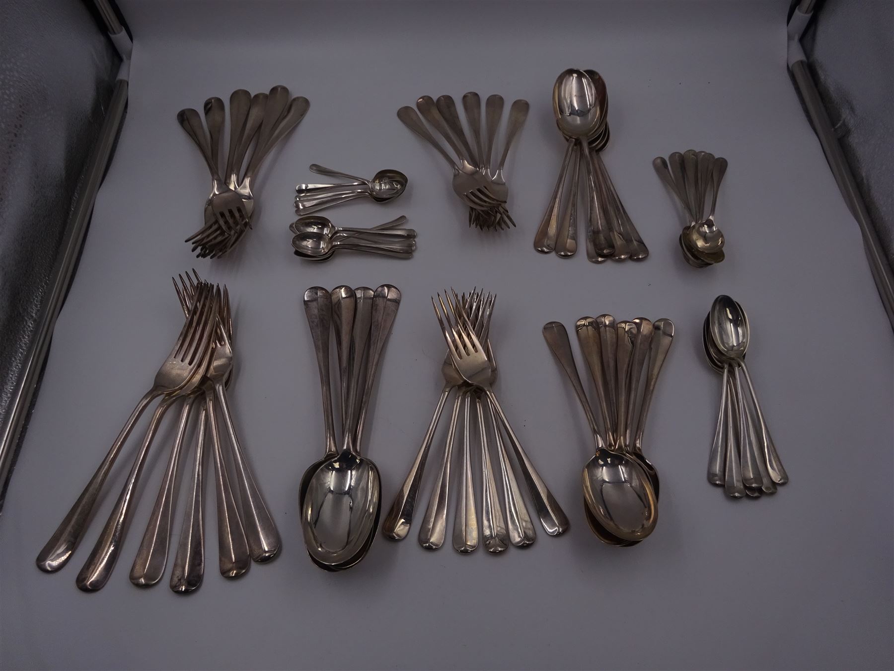 1930s matched set of silver Hanoverian pattern flatware, each with rattail bowls, to include four table spoons, twelve dessert spoons, twelve table forks, twelve dessert forks, twelve teaspoons and twelve coffee spoons, all hallmarked with various makers and dates 