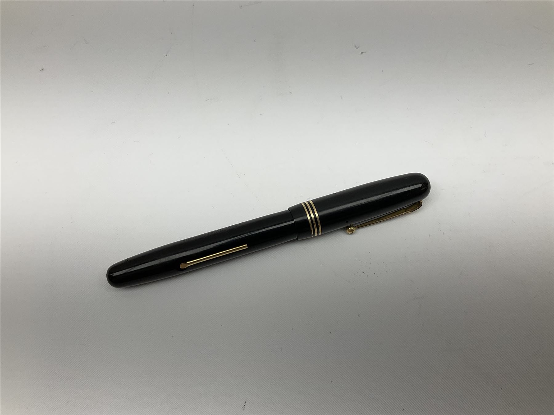 Vintage Swan Mabie Todd lever fill fountain pen in coral red, the nib a/f marked 14K, together with two further vintage Swan Mabie Todd fountain pens, the first example with lever fill, the other leverless, each with black body, one with nib marked 14ct, (3) 