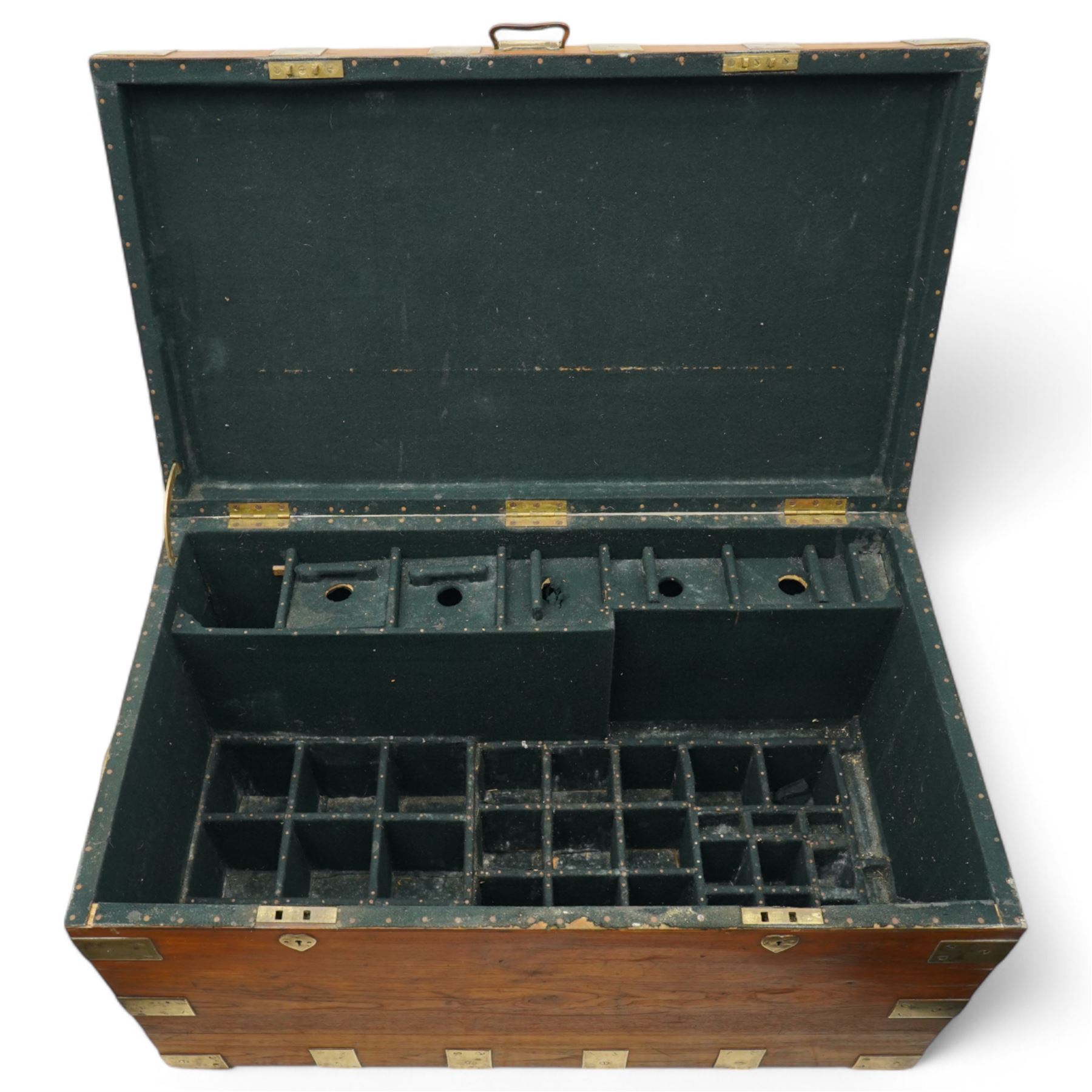 Early 19th century teak and brass bound silver campaign chest, fitted with brass L-shaped brackets and heavy weight carrying handles, the hinged lid enclosing two removeable trays with divisions and lined in blue baize, fitted with two 'R. Cooper & Son' brass locks
