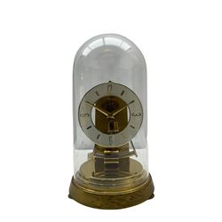 A  late 20th century German Kieninger & Obergfell, “Kundo” battery operated 
mantle clock under an acrylic shade, with an electrically operated solenoid pendulum housed on a 16cm circular brass base with three adjustable feet, skeleton movement with a visible escapement through an 4-1/2” open chapter ring dial, with gilt baton hands, three-hour numerals and baton markers.  H30cm 




