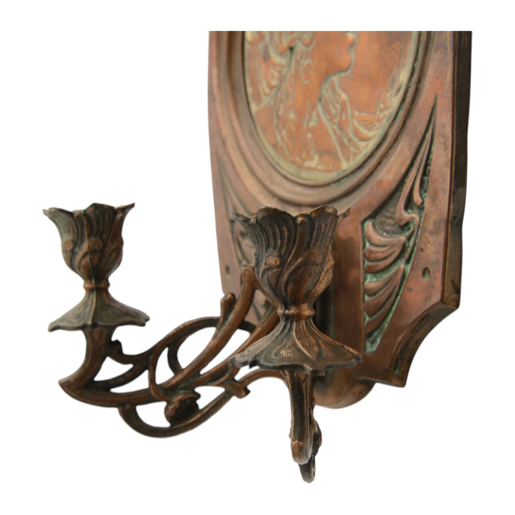 Pair of late 19th/early 20th century Art Nouveau copper twin branch wall sconces, each with shaped back plate chased with a central panel of a maiden in profile above and surmounted by foliate motifs, supporting two foliate open cast branches with bud sockets above conforming drip pans, H31cm W16cm D8.5cm
