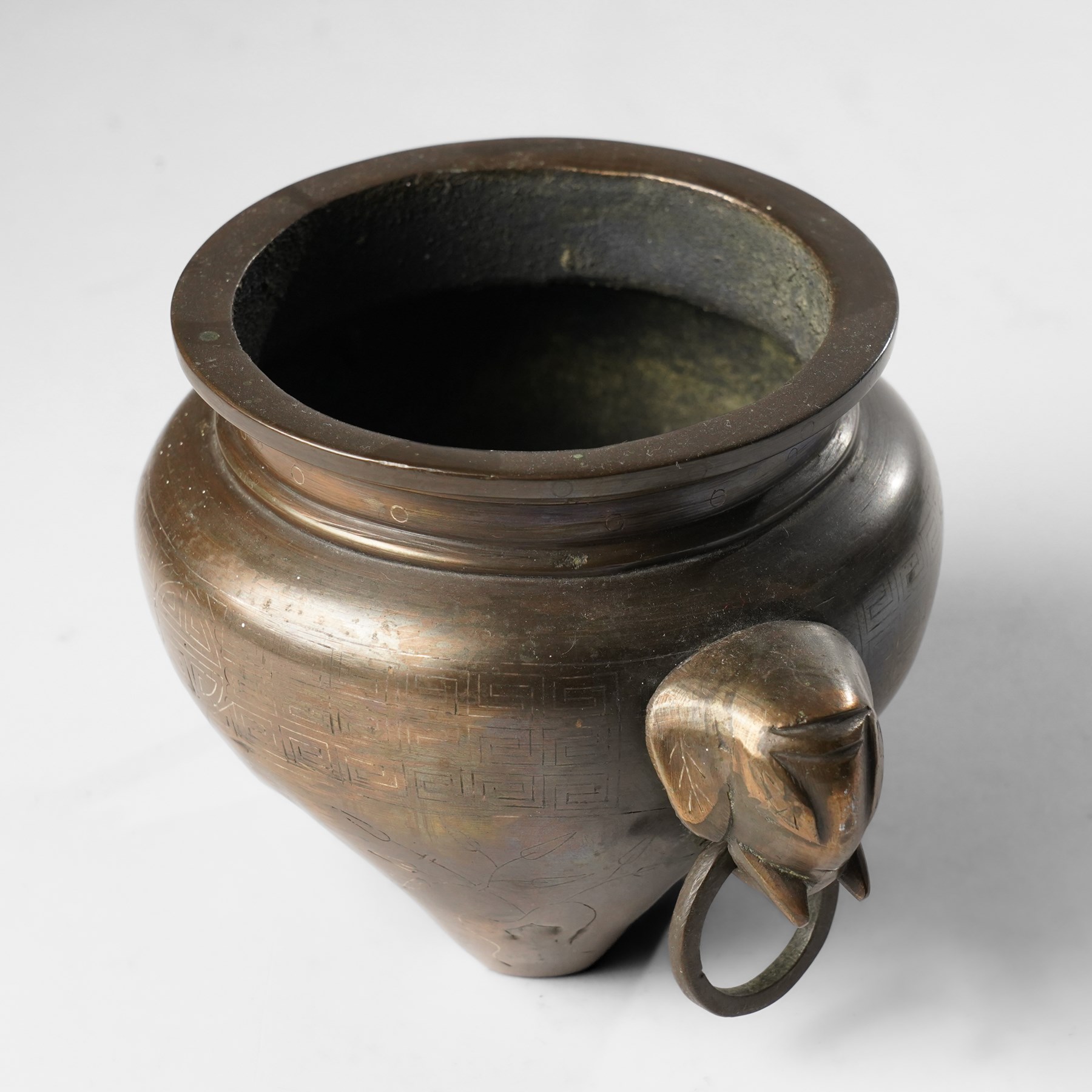 Chinese bronze tripod censer, of squat globular form, the body decorated with a band of Greek key motifs, the twin handles formed as two elephants heads, with incised shi shou two-character mark to base, H10cm