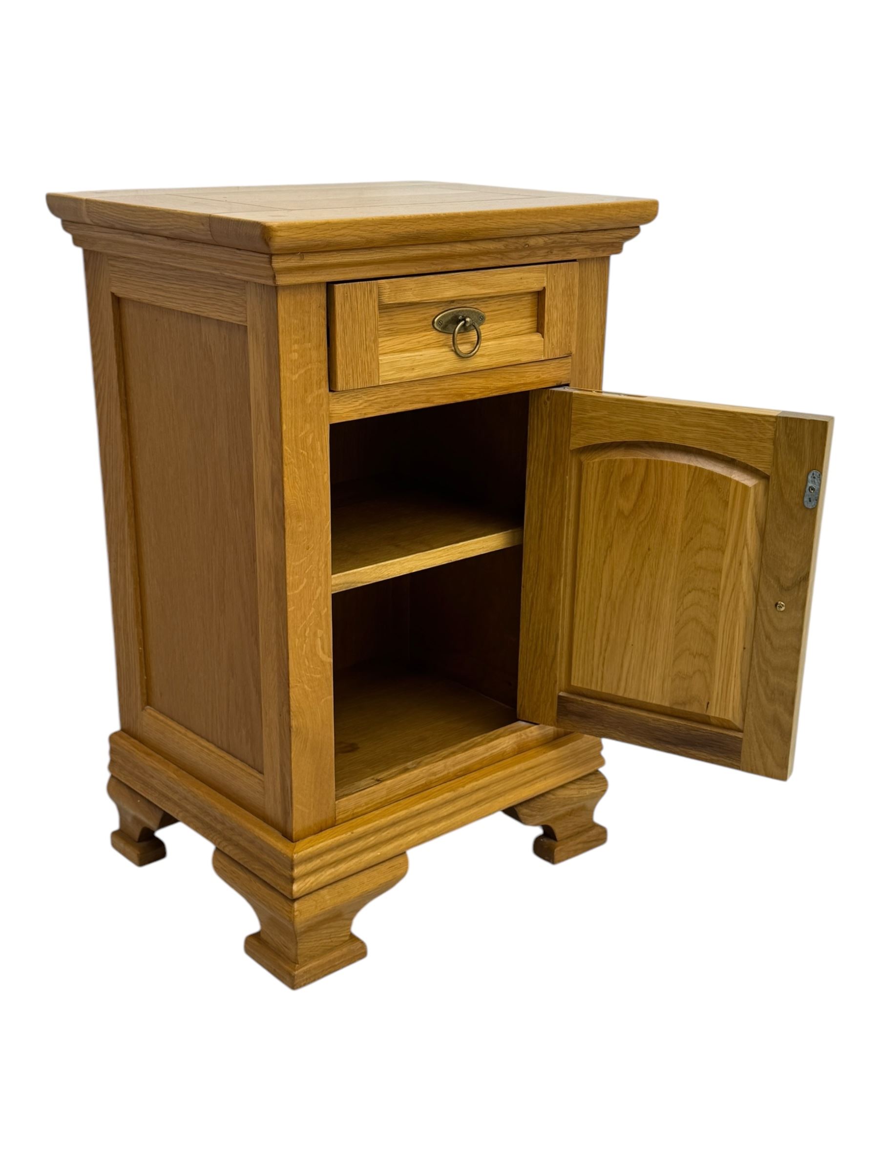 Frank Hudson - contemporary pair of light oak bedside cabinets, each with moulded rectangular top over single drawer above cupboard door with arched panel, on a moulded plinth base with bracket feet