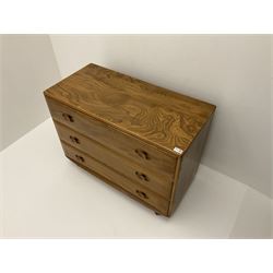 Ercol elm chest, fitted with three long drawers, raised on castors 