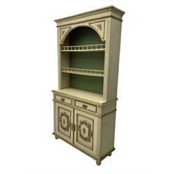 Portuguese painted dresser, two-tier plate rack with spindle gallery, flanked by fluted uprights, fitted with two drawers over two cupboards, the panelled cupboards with floral decoration and a rinceaux border, white painted and parcel-gilt 