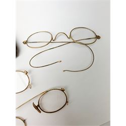 A pair of 9ct gold framed antique spectacles, marked 9 375, with case, together with a further pair, (testing around 9ct), and damaged pair (testing as gold plated). 
