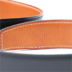 Hermès - reversible black and tan leather belt, with large gilt-metal circular openwork H monogram buckle, size 80, with buckle dust bag and belt dust bag