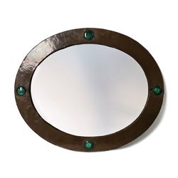 Liberty & Co, Arts and Crafts hammered copper framed oval wall mirror, mounted by four tur...
