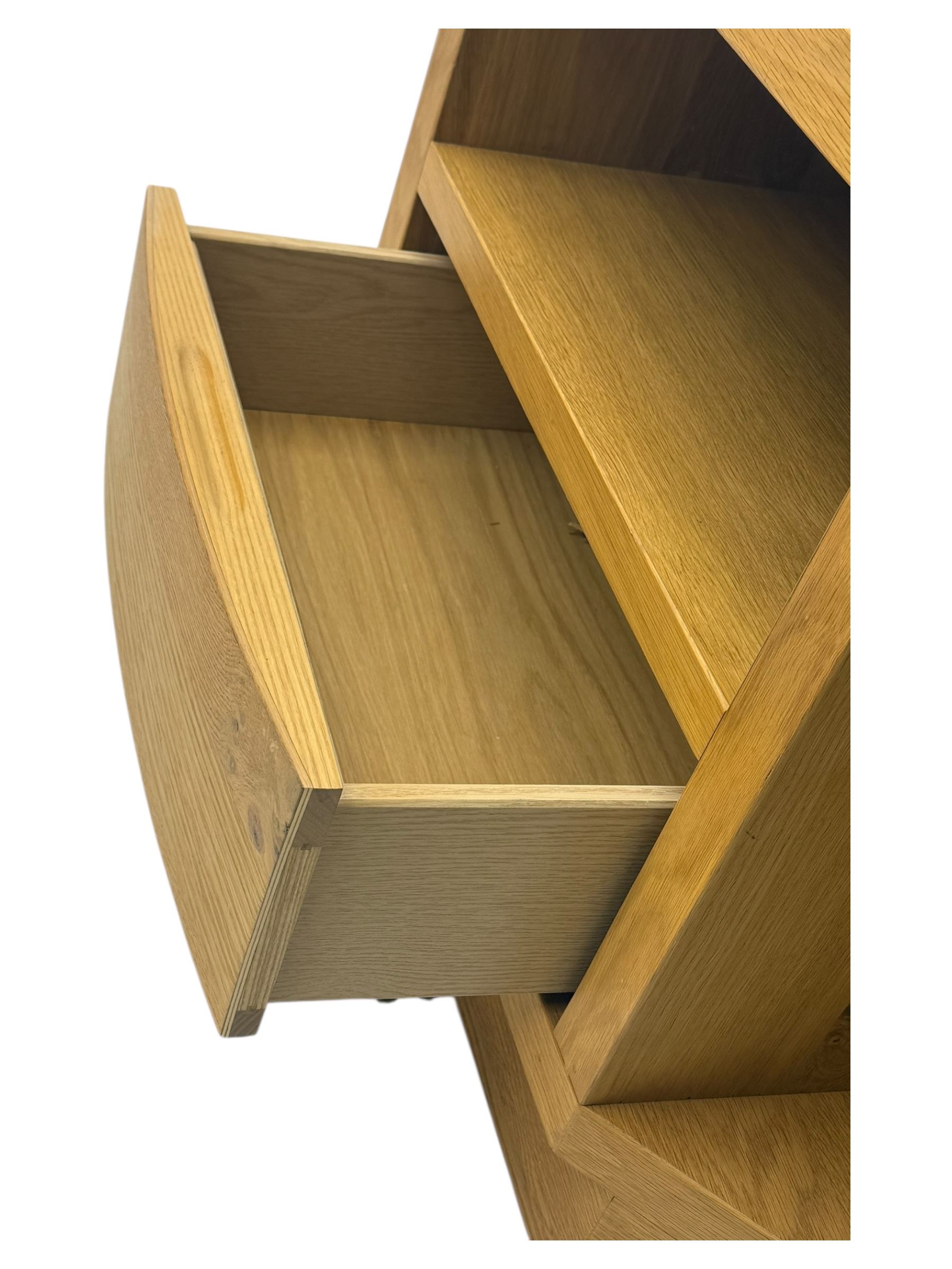 Contemporary light oak corner television stand, hexagonal top with central open section and lower drawer, shaped sides on integral plinth