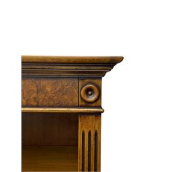 Georgian design walnut open bookcase, projecting cornice over figured banded frieze flanked by roundels, fitted with six adjustable shelves with flanking fluted uprights, on skirted base