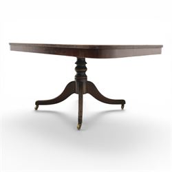 Regency mahogany tilt-top dining table, crossbanded rounded rectangular top, raised on a splayed base, terminating in brass castors