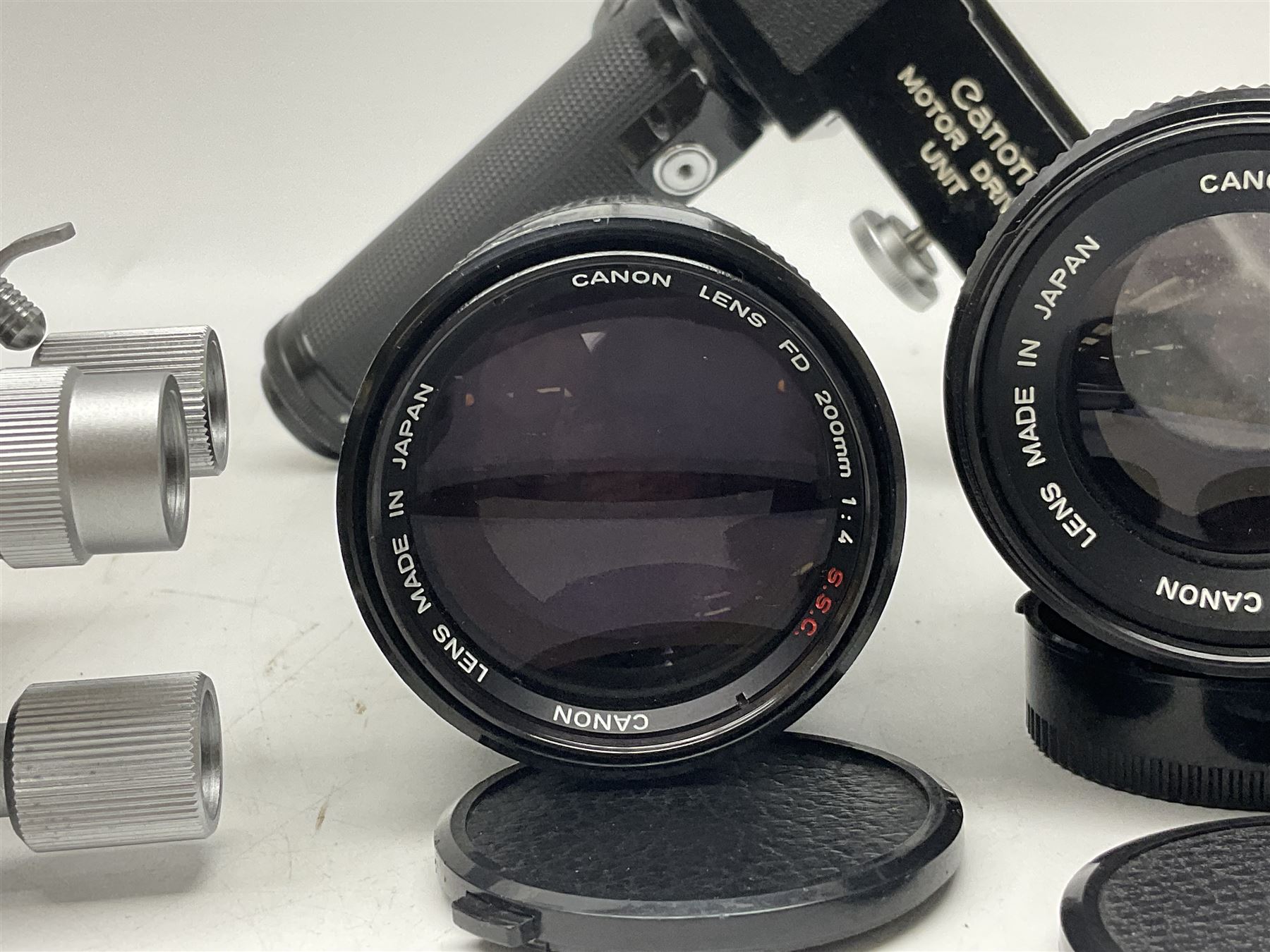 Collection of Canon lenses, to include 'Canon Lens FD 100mm 1:2.8', serial no 12821, 'Canon Lens FD 200mm 1:4' serial no 245313, 'Macro Canon Lens FL 50mm 1:3.5', serial no. 25505, 'Canon Lens FD 135mm 1:3.5 etc, together with other Canon equipment, including Bellows FL, Slide Duplicator etc 