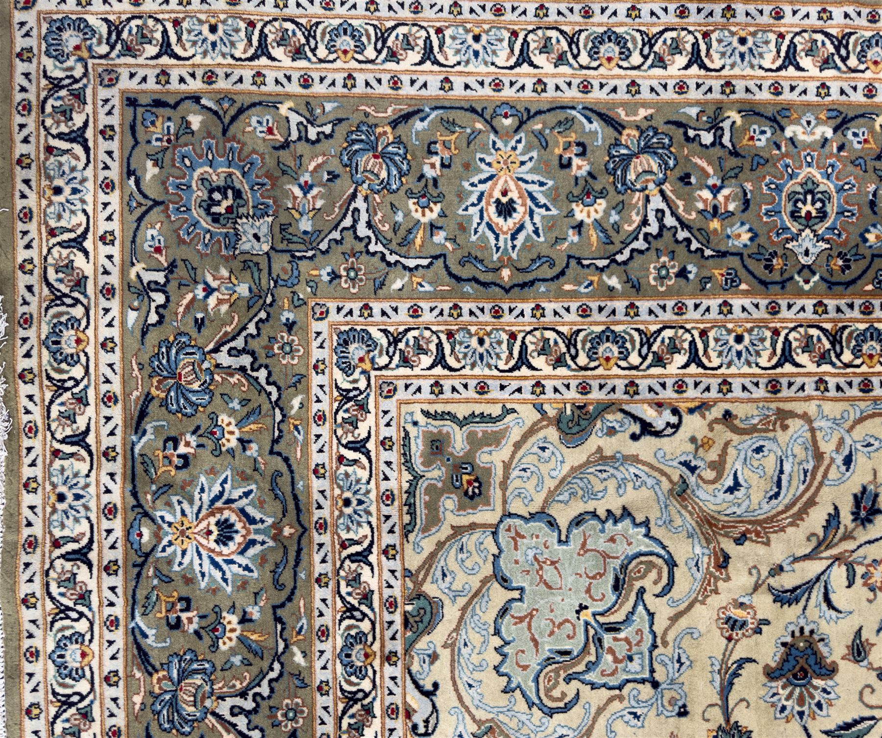 Central Persian Kashan hand-knotted carpet, ivory field with scrolling vines, palmettes, and rosettes around a cusped medallion with pendants and spandrels within a blue ground border of palmettes and flowerheads, 388cm x 300cm